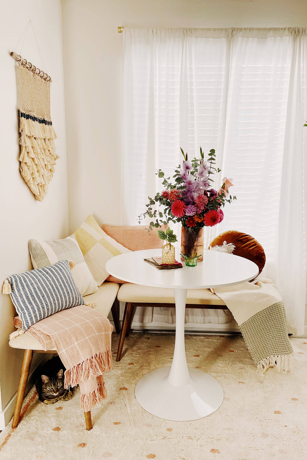 A light and bright dining nook with colorful pillows