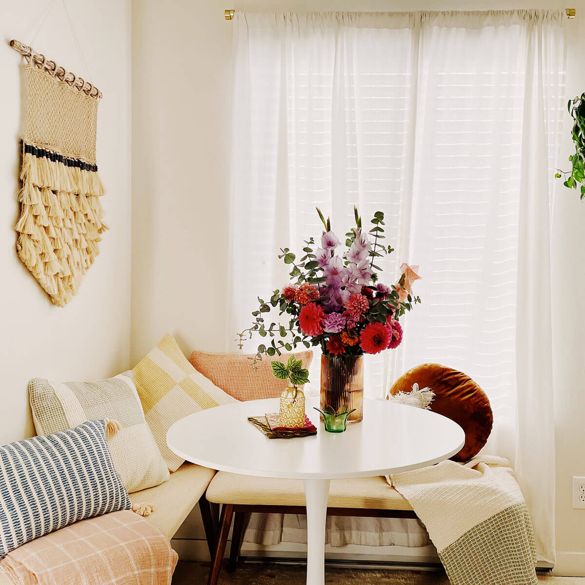 A light and bright dining nook with colorful pillows